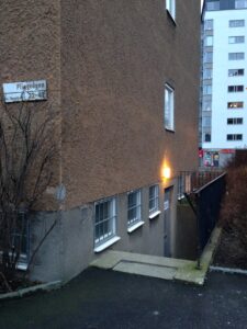 Entrén till Pliggvägen 42, en halv trappa ner vid gaveln